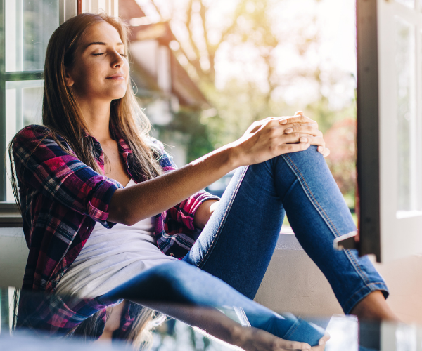 5 Ways To Support Your Mental Health During Lockdown Woman takes a deep breath by the window
